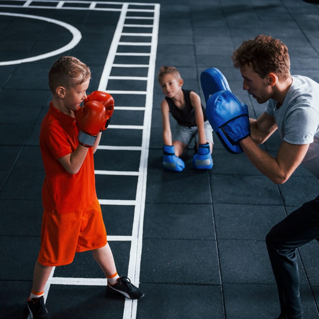 young-trainer-teaches-kids-boxing-sport-in-the-gym.jpg